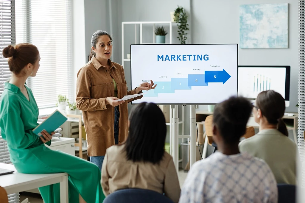Women Presenting Digital Marketing Strategies To Her Team