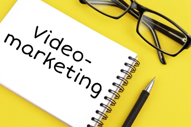 video marketing concept written on a notebook, featuring glasses and a pen