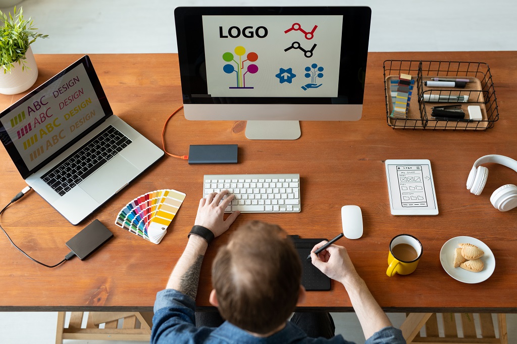 a designer sitting in front of a computer while focused on creating a business logo